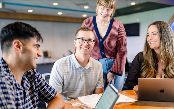 Summit employees working together at round table